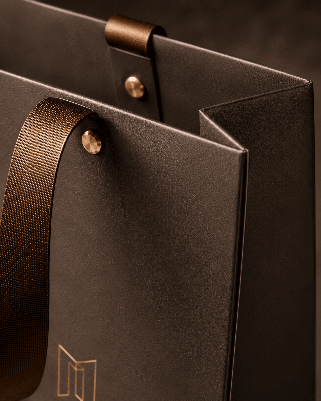 Gift bag construction detail showing textured paper, ribbon handles, reinforced handle points, and side gusset