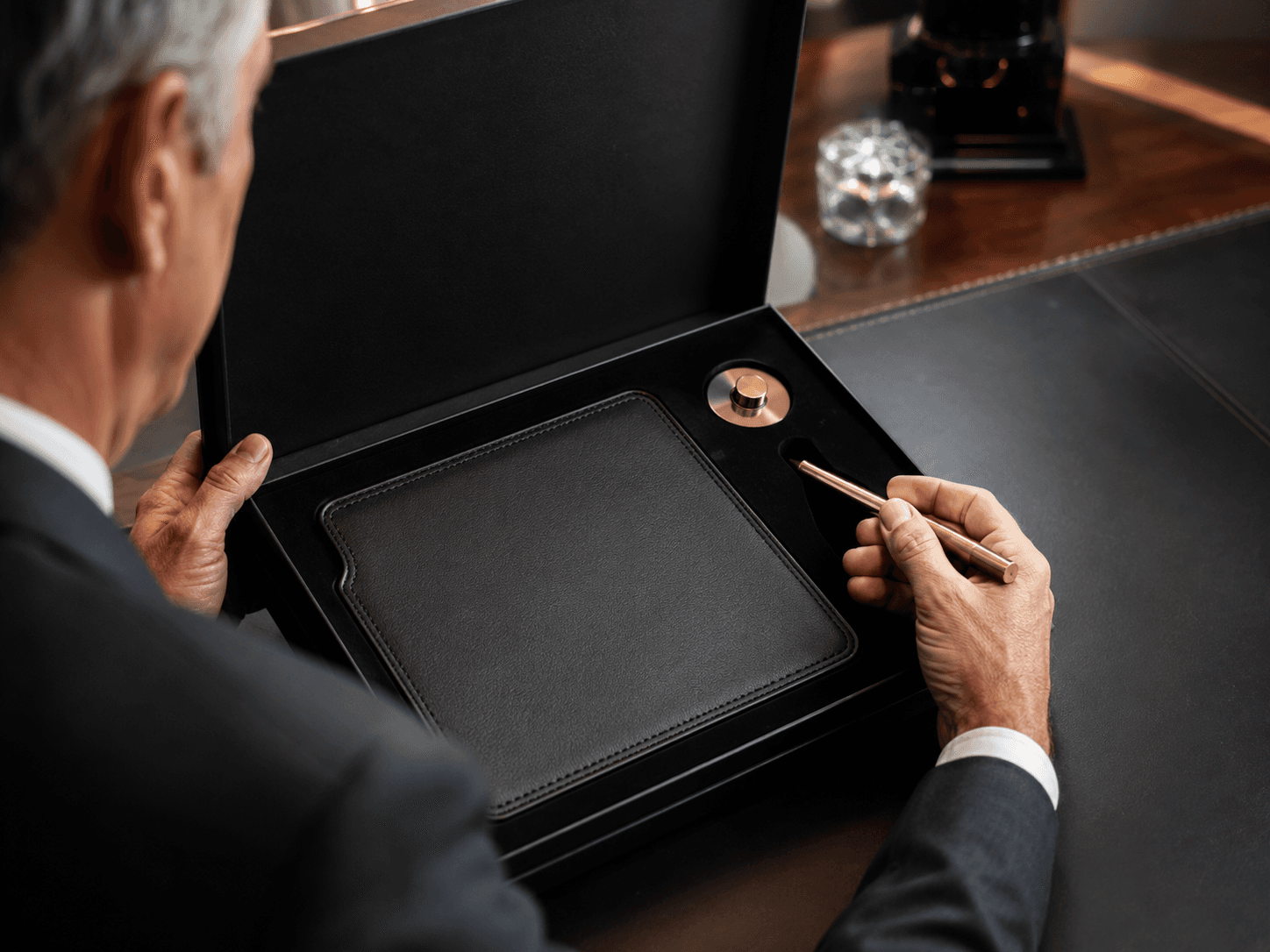 Tier-1 bank executive gift set — charcoal leather desk mat, machined brass floating pen, matte black presentation box