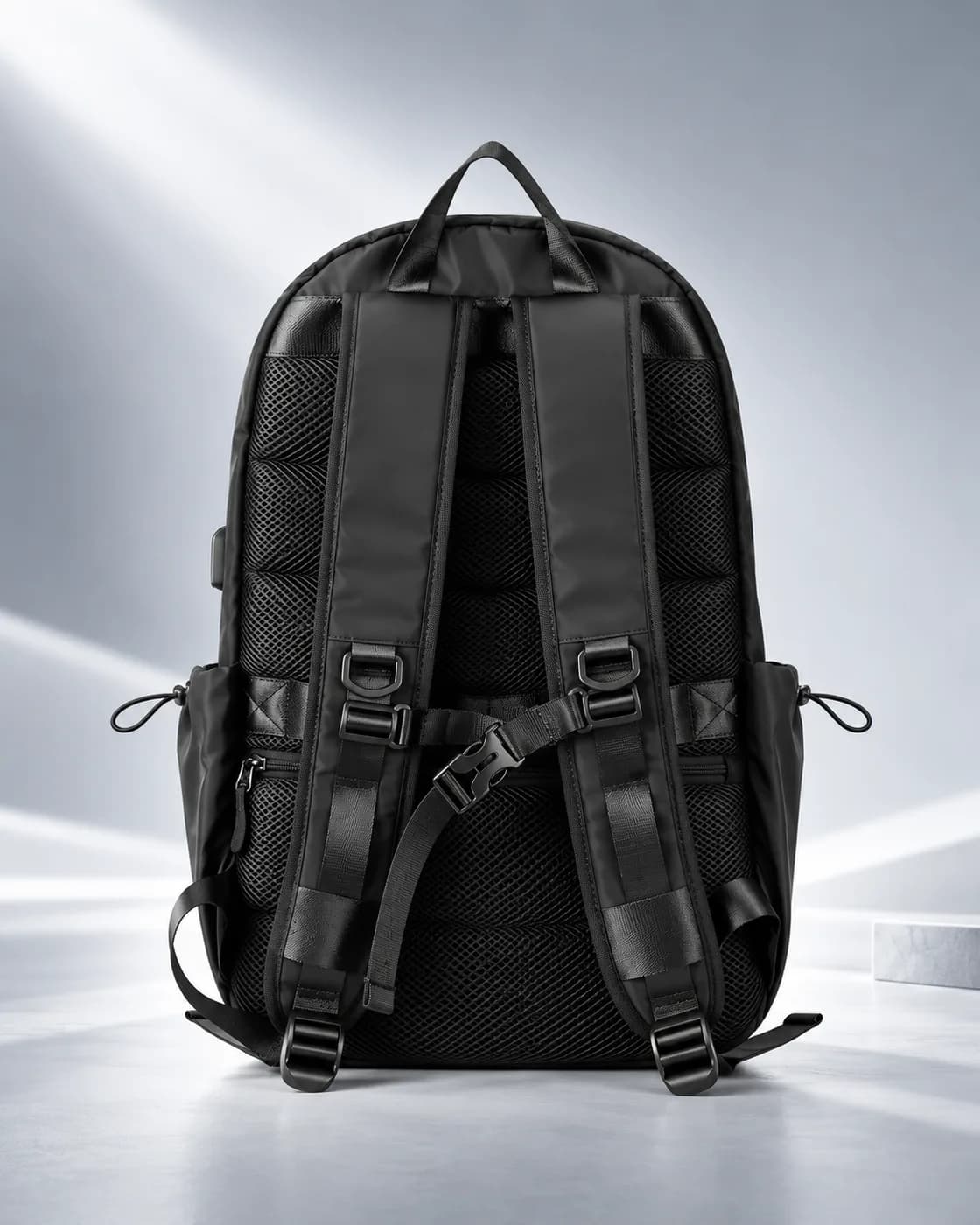 Rear view of the backpack showing mesh padding, adjustable shoulder straps, chest buckle and top grab handle