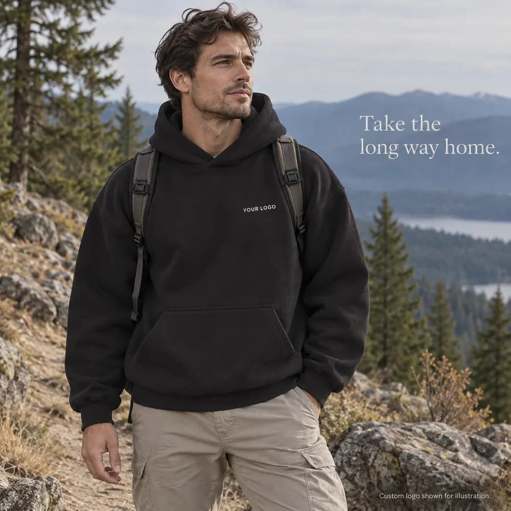 Adult man wearing a black custom hoodie on a wooded hiking trail